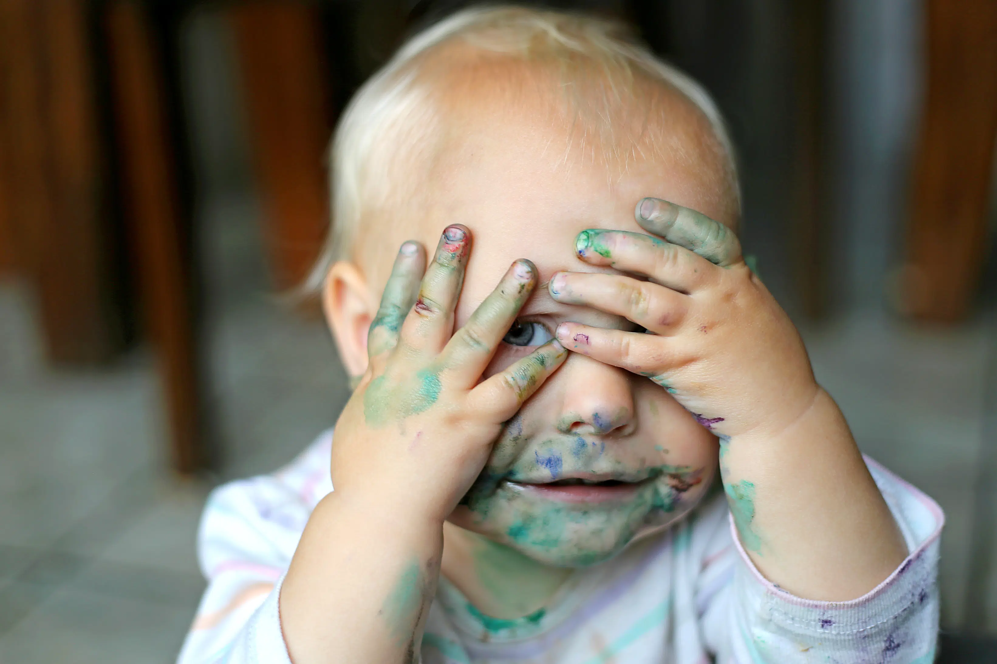 Cute,Baby,Girl,Covering,Her,Messy,,Painted,Face,With,Her